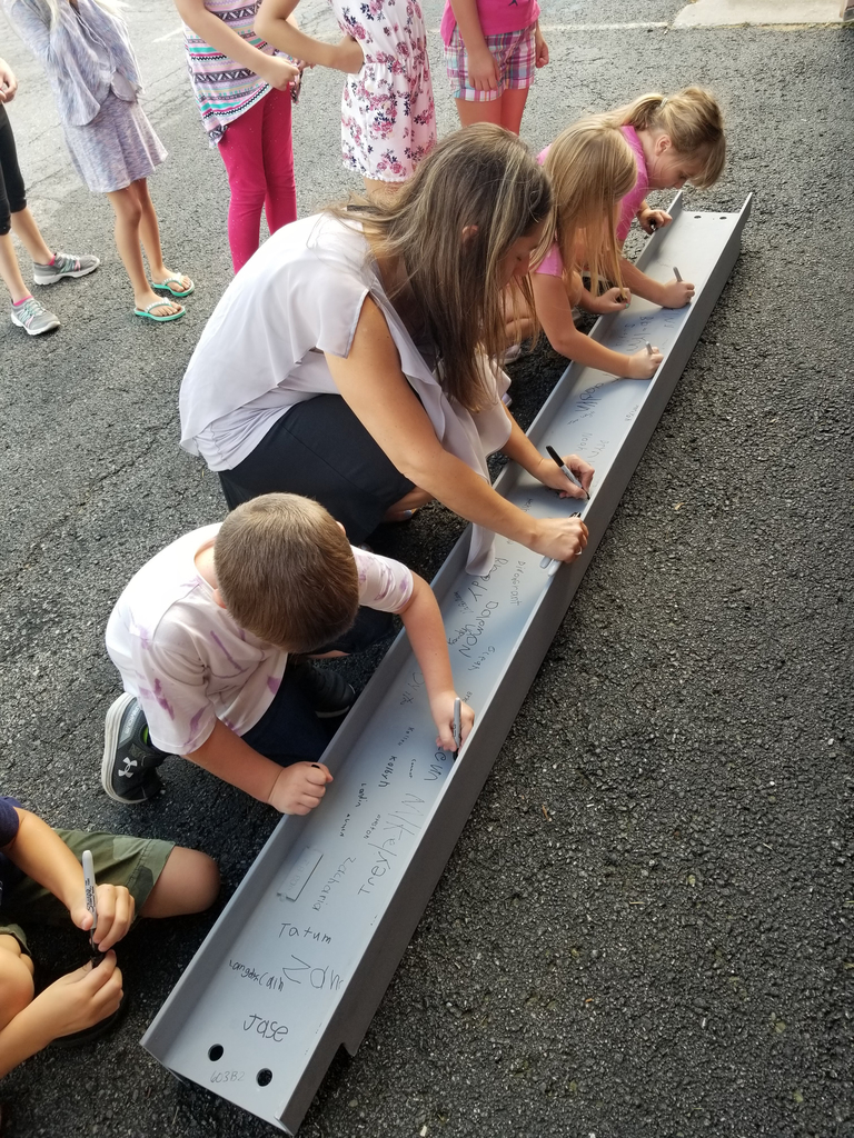 Students signing a beam that will go in the new school building.
